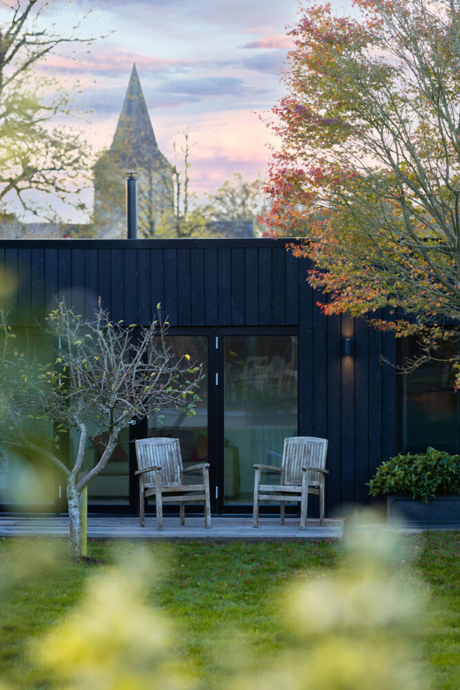 Garden room Cranleigh external with chairs and church